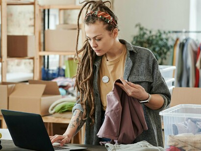 Mulher trabalha em loja de roupas de segunda mão. Hoje, o consumidor tem um papel activo na transformação do sector. Cada vez mais, as pessoas querem saber onde e como foram feitas as suas roupas, e que impacto tiveram no ambiente e nas condições de trabalho

