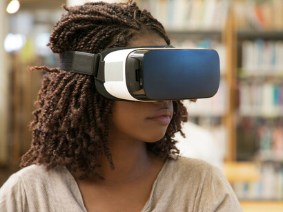 A woman wearing a VR headset, representing how access to advanced technology can allow women to take higher positions in the industry 