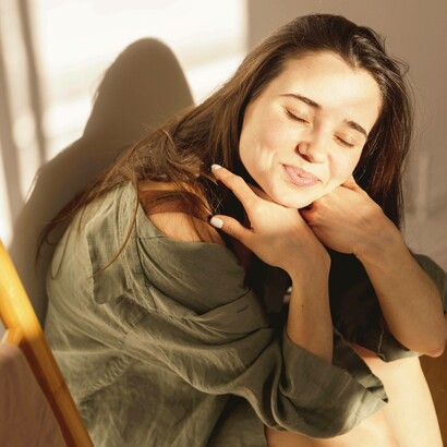 Giovane donna sorridente in una stanza e illuminata dalla luce del sole: "Riprendiamoci il nostro tempo, quello dell’attesa di una cartolina o di rivedere quel sorriso. Riprendiamoci la semplicità di uno sguardo e di un tocco e di un regalo"