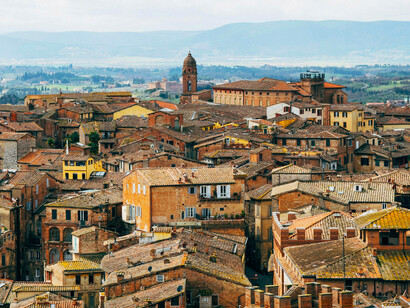 Aerial perspective showcasing a traditional Tuscan building surrounded by rural landscapes in Asciano, Tuscany, Italy