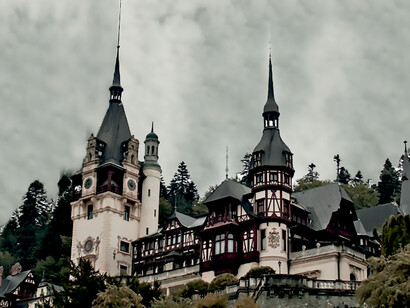 A large, eerie castle featuring a clock tower, located in Romania