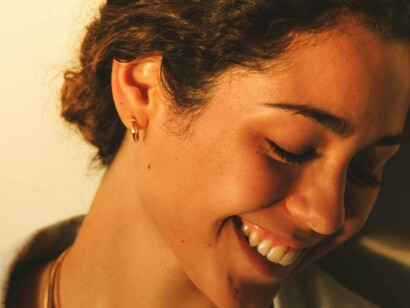 A smiling woman reflects the soothing effect of tuning into bodily sensations—a key practice in anxiety-reducing morning routines