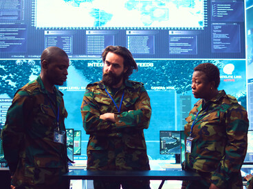 A command team engaged in discussion, representing the collaboration that drives modern defence strategies