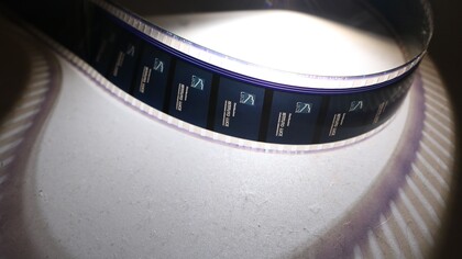 Una pellicola, con logo dell'Istituto Luce, da 35 mm illuminata dalla torcia di uno smartphone, scattata durante una mostra al Centro Culturale PUCP. Foto di Mayimbú