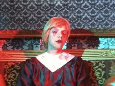 With an otherworldly aura, the stark red lighting amplifies the spectral presence of Drab Majesty, mirroring the descent into faith and fate