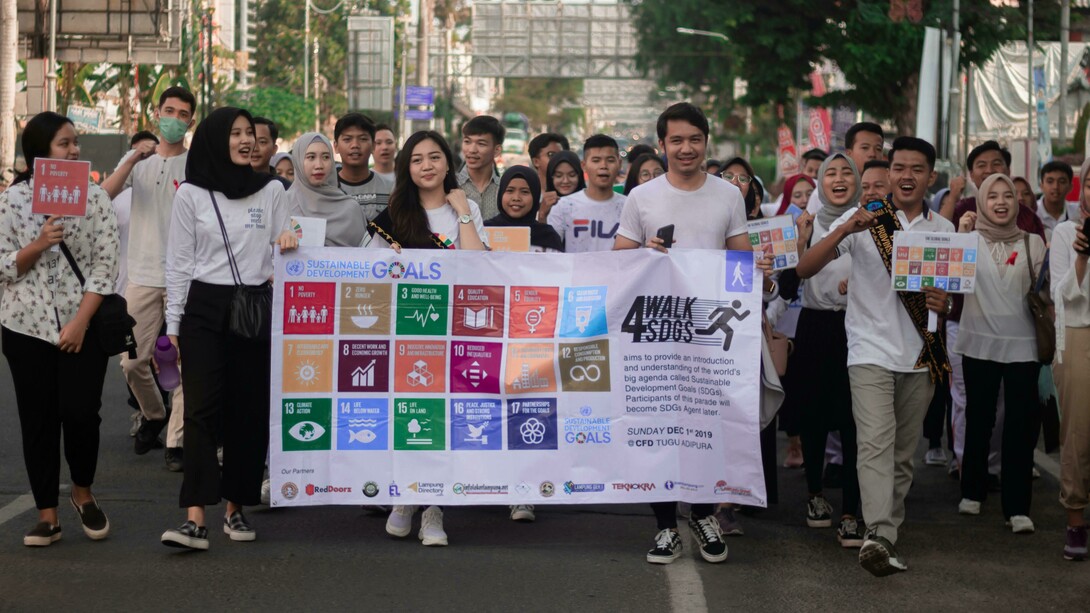 A group of people in Jakarta, Indonesia, hold a white banner promoting the Sustainable Development Goals