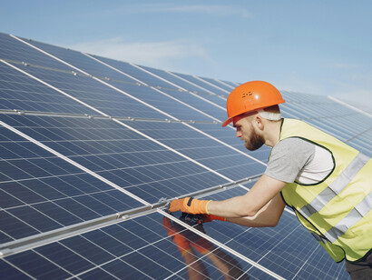 An electrician working on the installation of a solar panel
