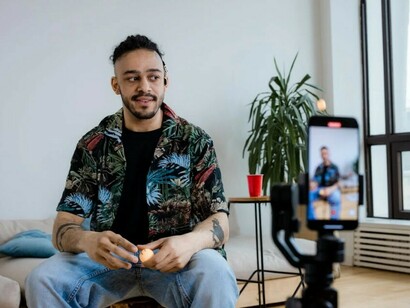 A man blogging on his smartphone, reflecting the digital media trends and the influence of social media creators