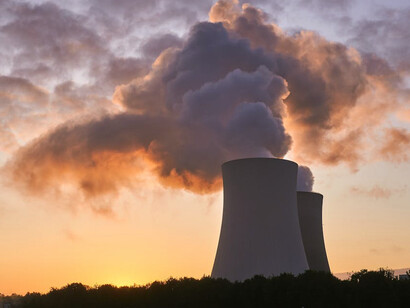The power station's silhouette against the sunset highlights the ongoing struggle between economic development and environmental sustainability in South Africa's energy policies