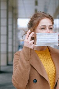 Mulher coloca máscara durante a pandemia do COVID