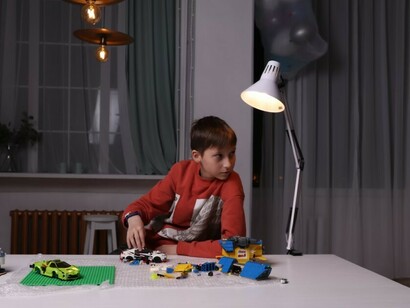 A young boy is playing with LEGO bricks at a table