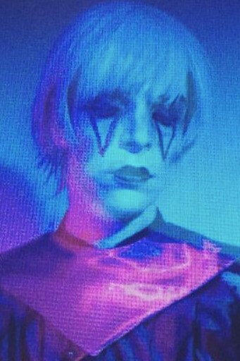 With an expression frozen in time, the spectral presence of Drab Majesty is heightened by the dreamlike glow of purple light