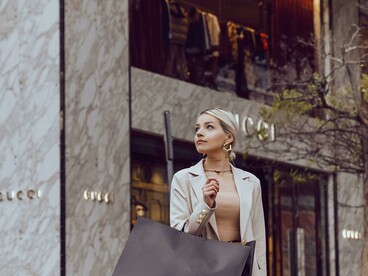 A stylishly dressed woman stands shopping in front of the Gucci store in İstanbul, Türkiye