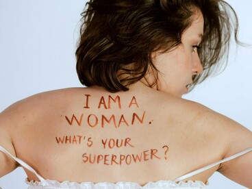 A woman with the message on her back, reflecting the untapped economic power women carry every day
