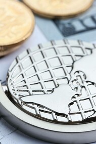 Monete, cartamoneta e mappamondo su sfondo bianco con grafici: "A partire dal 2008, infatti, le Banche Centrali introdussero tale nuova dottrina economica: avrebbero garantito immissioni “illimitate” (sono parole loro) di mezzi monetari a corso legale onde evitare le classiche crisi bancarie dovute a carenza di liquidi"