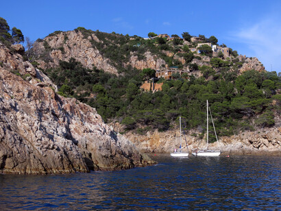Escapando del fuerte oleaje y del vendaval, troté sobre la arena húmeda.Cala Pola y el Macizo de las Sillitas, Tossa de Mar) Costa Brava, España