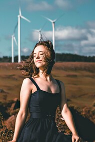 A woman posing by windmills