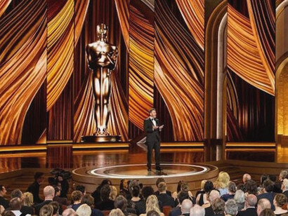 A packed audience looks on as the presenter speaks, yet outside the Dolby Theatre, younger viewers are tuned in to stories the Academy still overlooks