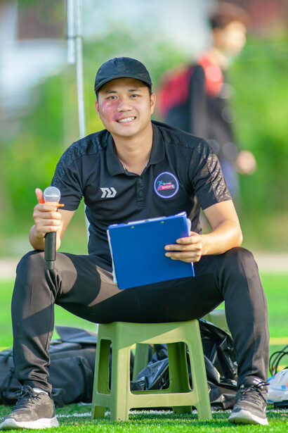 The sporting director and football manager watch as a man works on a portable computer at the training ground