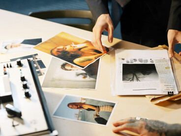 A person in a suit examining photographs during a federal investigation