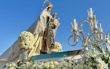 L'image montre une statue religieuse, spécifiquement identifiée comme une statue de la Vierge Carmen lors d'une procession dans la ville d'Andalousie, en Espagne