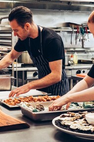 Chefes de cozinha preparam uma entrada para evento gastronômico
