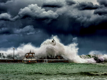 Powerful waves under a dark, cloudy sky, representing a post-earthquake tsunami