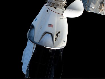Il veicolo spaziale senza equipaggio SpaceX Crew Dragon è il primo veicolo commerciale per il trasporto di equipaggi in visita alla Stazione Spaziale Internazionale. Qui è raffigurato con il cono di prua aperto che rivela il suo meccanismo di aggancio mentre si avvicina al modulo Harmony della stazione