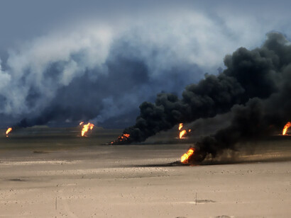 Oil well fires burn outside Kuwait City after Iraqi forces set them ablaze before being driven from the region by coalition forces during Operation Desert Storm