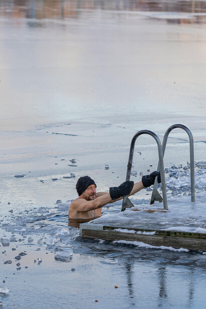 A man immersed in a frozen lake, embracing the cold plunge ice bath ritual for health, resilience, and longevity