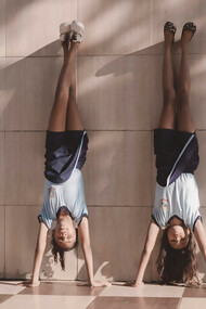 Four student-athletes leaning against the wall represent the balance they maintain between their academic and athletic responsibilities, demonstrating teamwork and resilience