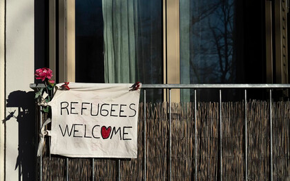 A sign reading "Refugees Welcome" displayed on a building