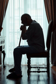 Elderly man sits alone in his room, pondering life's unanswered questions