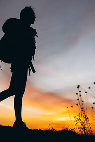 A woman rucking on the mountain during sunset