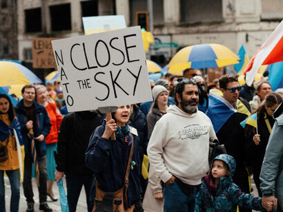 People holding umbrellas as they walk through the streets of Seattle USA, participating in an anti-war protest in solidarity with Ukraine