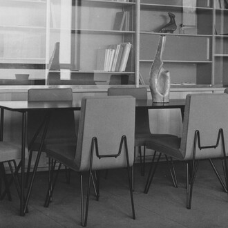 Das Büro des Geschäftsführers mit einem wandmontierten Bücherregal und einem Konferenztisch
sowie den Stühlen mit Metallgestell entworfen vom Architekturbüro Jean Tschumi