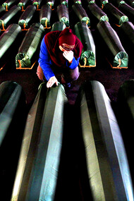 Donna che piange davanti a una bara