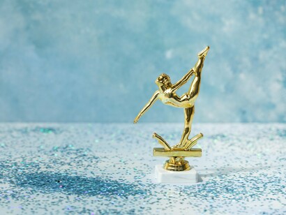 A trophy resting against a plain blue surface, symbolising the value of celebrating incremental progress