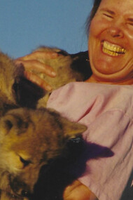 Susan Eirich holding the pups with a wide smile on her face