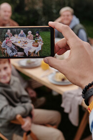 A smartphone captures a family having dinner