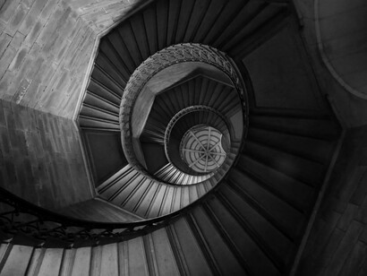 Black and white photograph capturing the geometric beauty of a spiral staircase