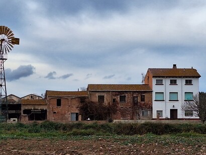 Del cuidado de los campos se encargan los habitantes de las masías que sobrevivieron a la expropiación, como la gran Torre d’en Malla o la masía de Can Salvi.  Molino de viento,  Gallecs, Barcelona, España
