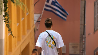 A man walks along a quiet sidewalk in Greece
