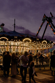 Parco a tema con giochi e persone che si esibiscono in un circo