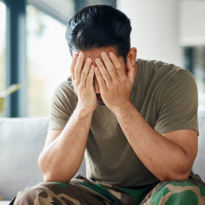 An army man in quiet reflection, his posture heavy with exhaustion and mental strain — representing the unseen battles of PTSD and depression