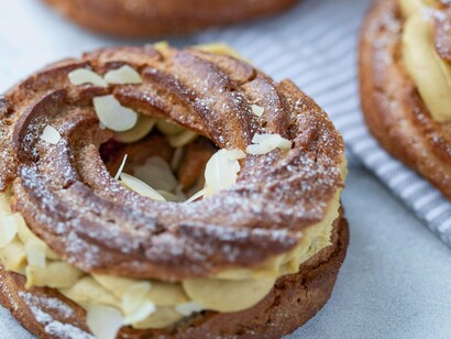 Un Paris-Brest est une pâtisserie française classique composée d'un anneau de pâte à choux fourré d'une riche crème mousseline pralinée aux noisettes