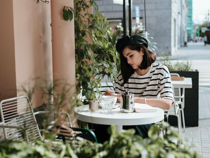 Mulher lê em mesa de café. Ler e entender um texto para muitas pessoas é impossível, principalmente quando são usadas palavras mais complexas, distantes do pequeno vocabulário dos pouco letrados, e não são pouco letrados somente quem não foi alfabetizado, também são os que tiveram alguma deficiência na alfabetização, inclusive as pessoas ditas bem alfabetizadas, mas que não desenvolveram o hábito da leitura no decorrer da vida