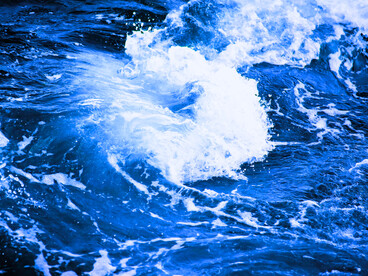 Expansive waves rolling across a bright blue sea, conveying the slow unravelling of old walls as you return to your truest self