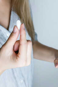 Pessoa busca um copo d'àgua para tomar um remédio anti-inflamatório