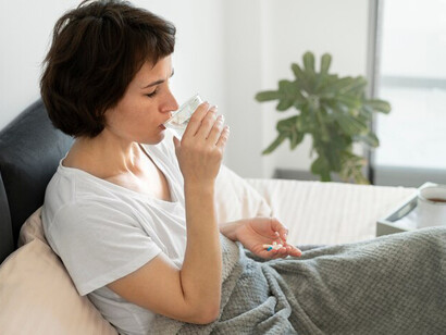 A woman in bed, overwhelmed by chronic illness, fatigue, and the effects of thyroid dysfunction